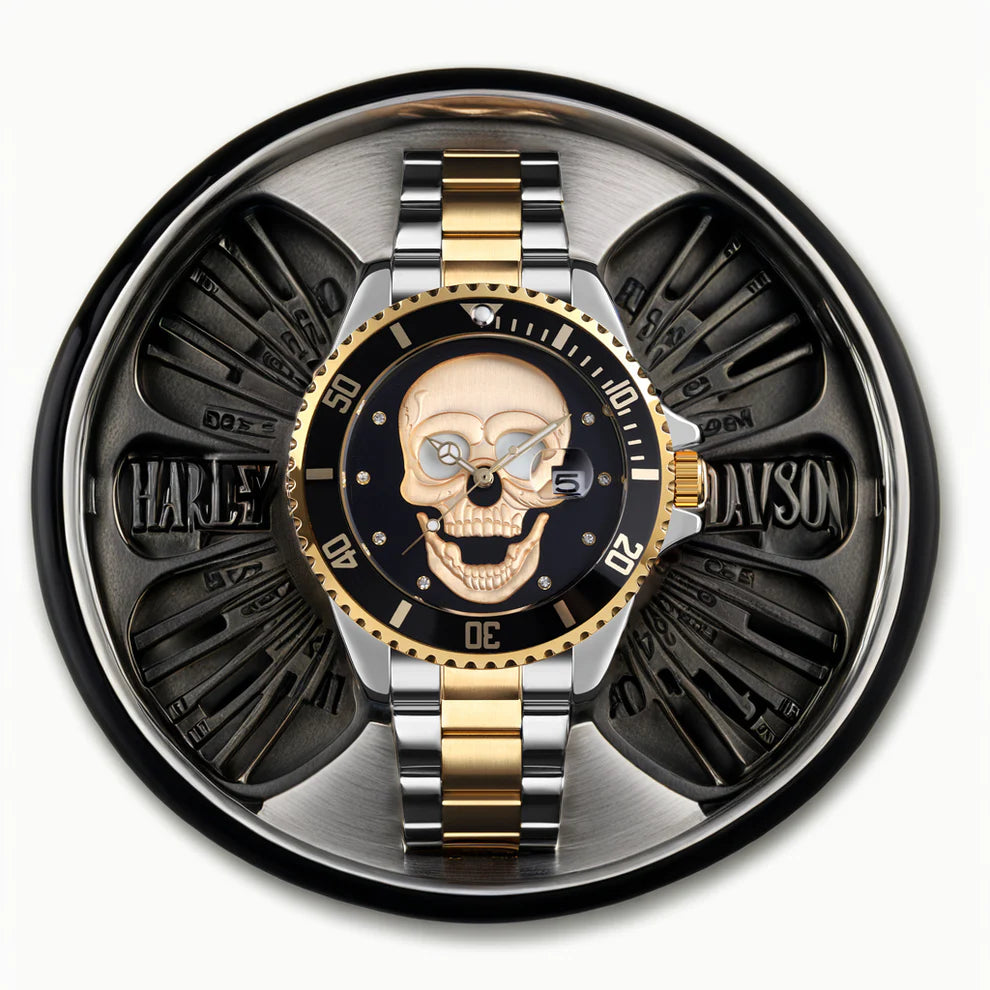 L'orologio PACOSHOP con teschio 3D oro argento nero, caratterizzato da un audace design a teschio, si trova in cima a una parte del motore Harley-Davidson con il nome Harley-Davidson ben visibile nel metallo.