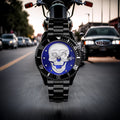 L'Orologio con teschio 3D black blue di PACOSHOP è in primo piano davanti a una moto su strada urbana, con auto sfocate sullo sfondo: un orologio al quarzo che fonde stile metropolitano e design originale.