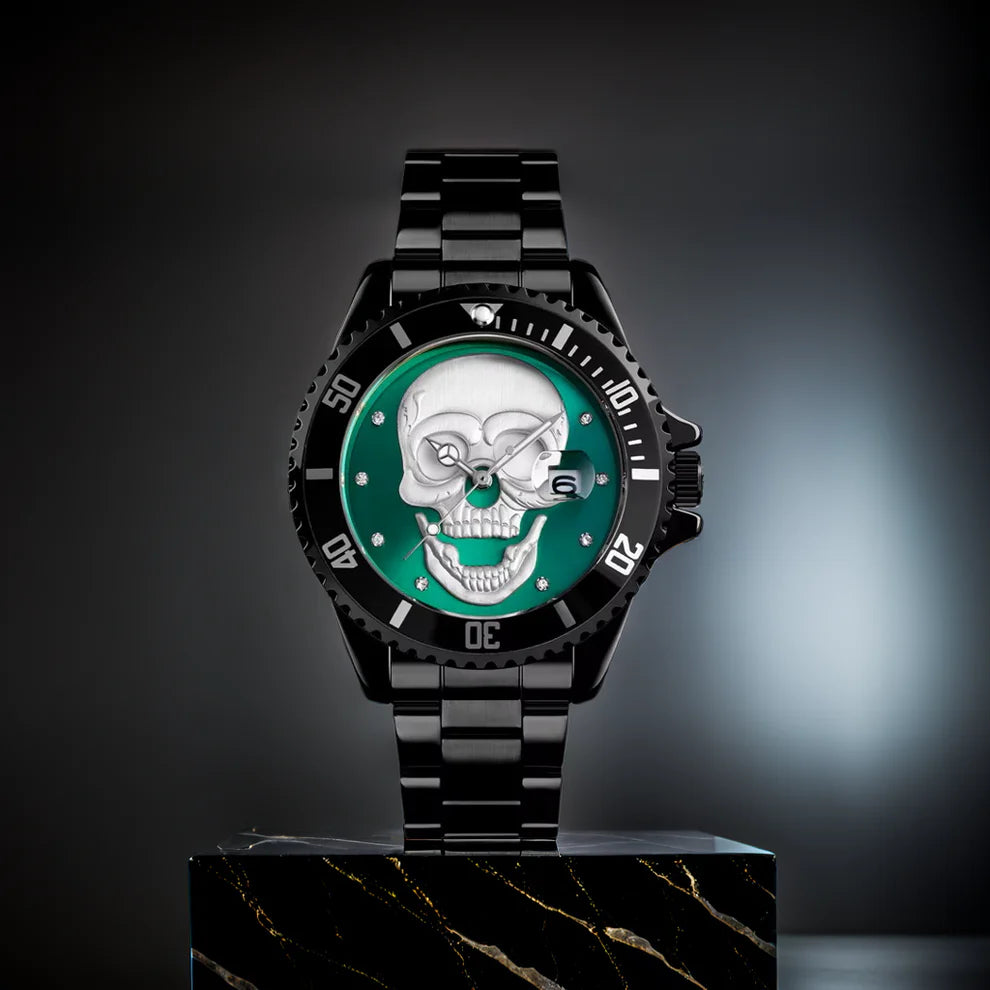 L'Orologio con teschio 3D black green di PACOSHOP è un orologio al quarzo in metallo nero con quadrante verde e teschio argentato dettagliato, esposto in verticale su un blocco di marmo nero su uno sfondo scuro e sfocato.