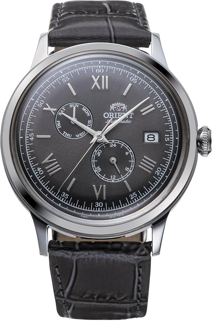 L'Orient Bambino Automatico RA-AK0704N30B di Orient è dotato di cinturino in pelle nera, quadrante nero con numeri romani, contatori multifunzione per il giorno e le 24 ore, datario a finestrella a ore 3, lancette e indici argentati.