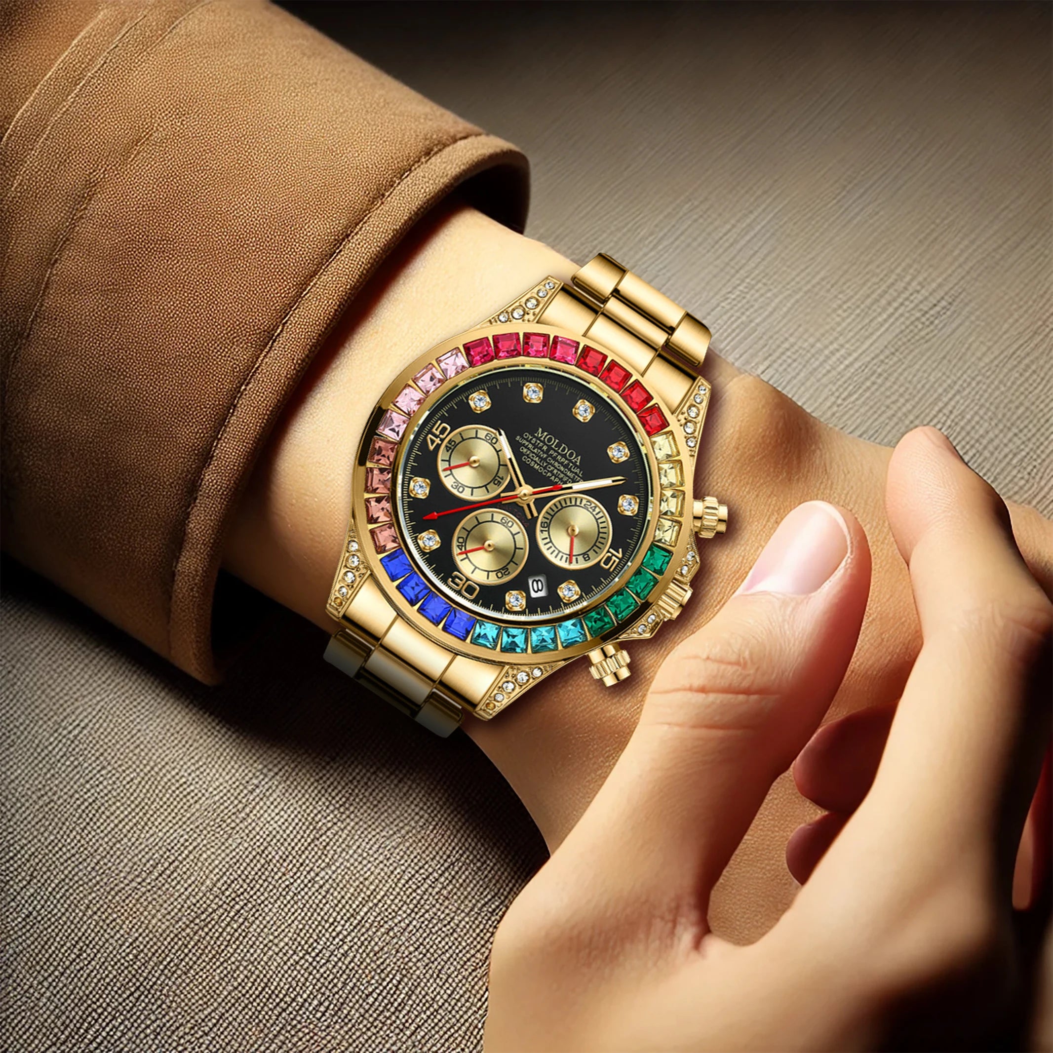 Un PACOSHOP24.COM Orologio uomo Mod. Rainbow L'orologio da polso al quarzo in edizione limitata con quadrante nero, lunetta con gemme colorate e tre contatori viene indossato mentre viene regolato su una superficie in tessuto marrone.