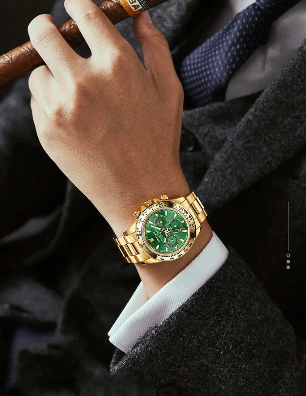 Una persona in abito scuro tiene in mano un sigaro, indossando un PACOSHOP24.COM orologio automatico uomo cronografo con lunetta in ceramica e vetro zaffiro, quadrante verde e tre contatori, che emana lusso e raffinatezza.