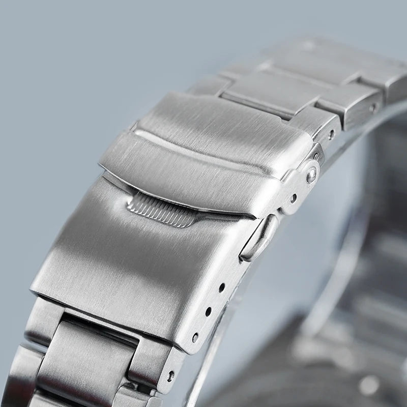 Primo piano dell'Orologio Automatico Acciaio Inossidabile vetro Zaffiro di PACOSHOP24.COM, che mostra la chiusura a bracciale in acciaio inossidabile spazzolato e il meccanismo di chiusura sicura su uno sfondo chiaro.