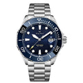 L'Orologio Automatico Acciaio Inossidabile vetro Zaffiro di PACOSHOP24.COM ha la cassa in acciaio inossidabile color argento, la lunetta e il quadrante blu, gli indici luminosi, la data a ore 3, le lancette color argento e la dicitura Automatico 100M/330FT.