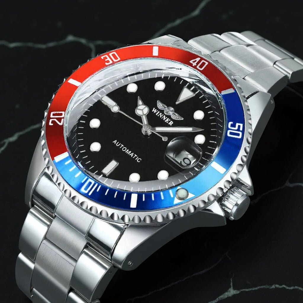 L'orologio automatico uomo meccanico PACOSHOP24.COM mod. Gmt ha la cassa in acciaio, il quadrante nero con indici bianchi, la lunetta rossa e blu e le indicazioni "WINNER" e "AUTOMATIC" sul quadrante, su una superficie di marmo nero.