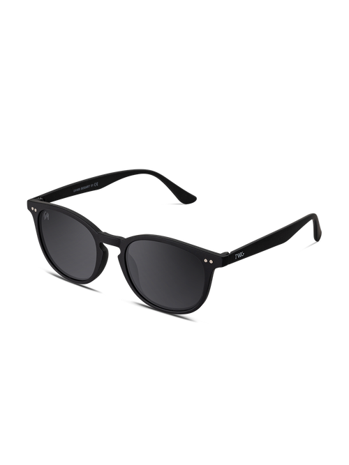 I TWIG Concept Milano Occhiali da sole Bogart sono occhiali da sole rotondi unisex di colore nero, con lenti scure, finitura lucida e angoli argentati. Realizzati in resistente policarbonato con protezione UV 400, su sfondo bianco.