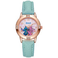 L'Orologio bambini cartoon Stitch di PACOSHOP24.COM ha un cinturino in pelle blu chiaro, una cassa in oro rosa e un quadrante con Stitch e Angel. Cristalli scintillanti e indici rosa rendono questo orologio quarzo affascinante per bambini e appassionati.