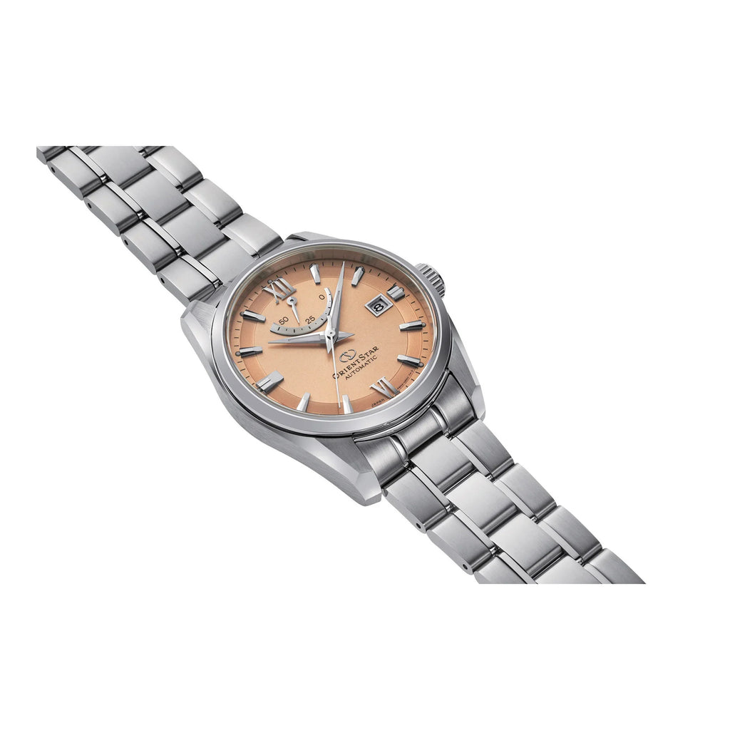 L'Orient Star Classic Automatico RE-AU0108G00B di Orient è caratterizzato da cassa argentata, quadrante arancione, indici argentati, data a ore 3 e bracciale in acciaio inossidabile, su sfondo bianco.