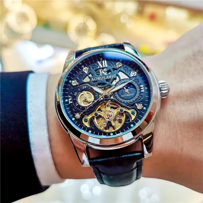 Primo piano del polso di un uomo elegante che indossa l'Orologio automatico scheletrato uomo Tourbillon Design di PACOSHOP24.COM, con cinturino in pelle nera, ingranaggi in oro a vista e quadranti blu sul quadrante.