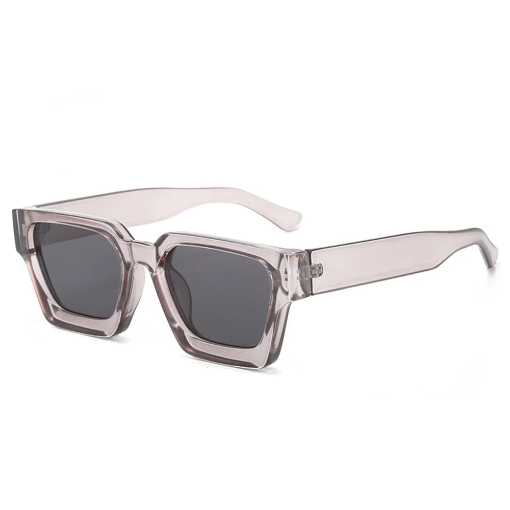 Gli Occhiali da sole con montatura quadrata Fashion Retrò Vintage di PACOSHOP24.COM sono caratterizzati da una spessa montatura rettangolare trasparente e da lenti UV400, disposte obliquamente su sfondo bianco.