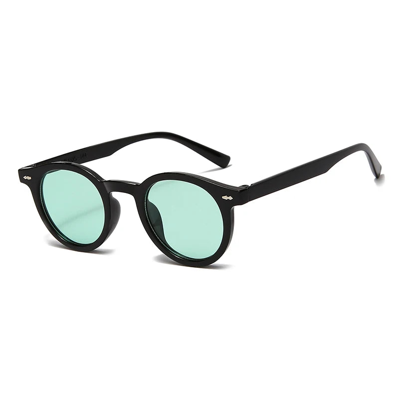 Occhiali da Sole Unisex stile Ovale moda di PACOSHOP24.COM con spessa montatura nera e lenti UV400 verde chiaro, visualizzati in posizione angolata su sfondo bianco.