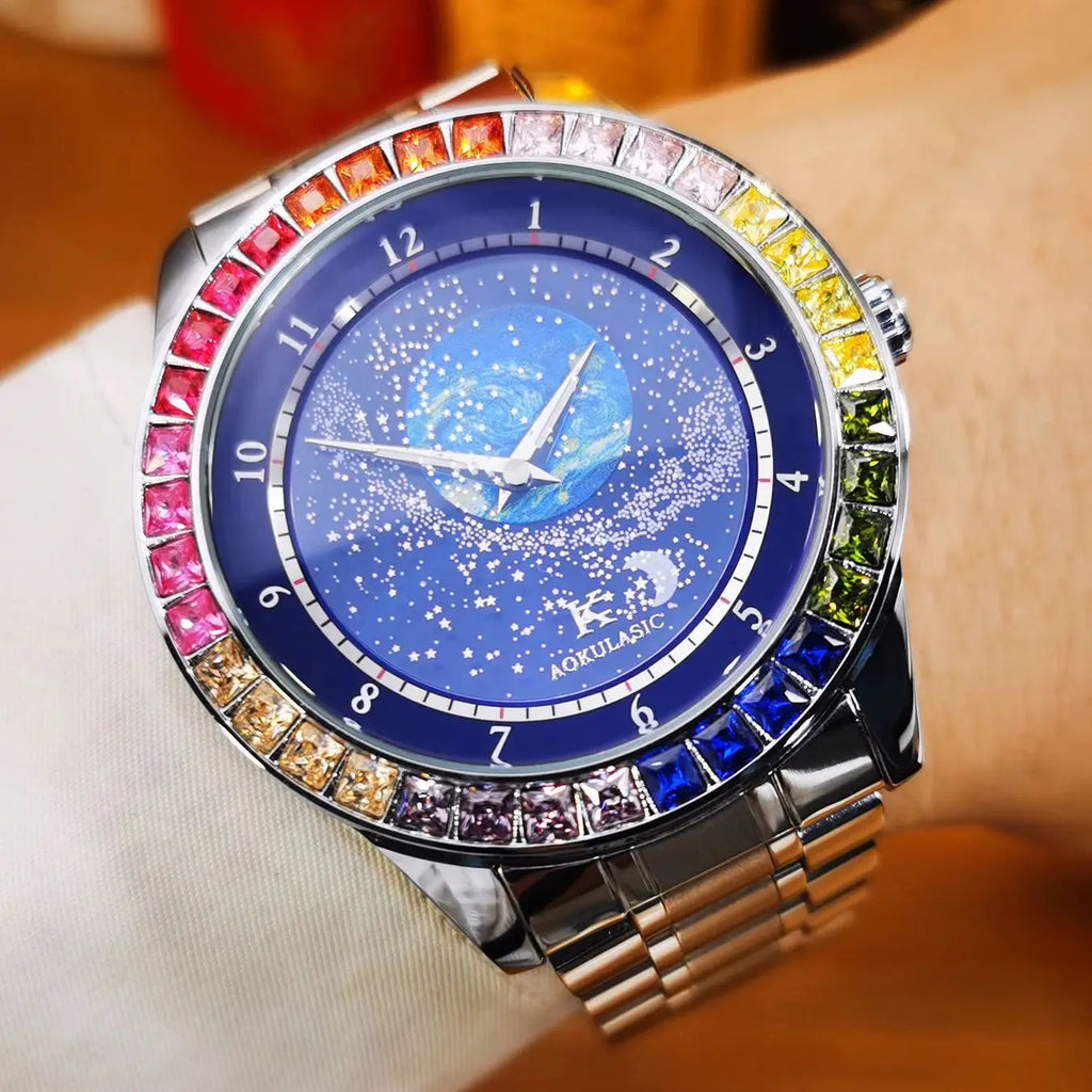 L'Orologio automatico uomo cielo stellato Design luminoso di PACOSHOP24.COM presenta una cassa argentata, un quadrante blu a tema stellare e una lunetta ornata di gemme sfumate arcobaleno per un look lussuoso. Mostrato al polso con una guaina chiara.