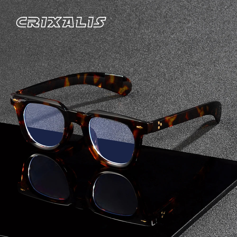 Un paio di occhiali wayfarer retro vintage unisex anti luce blu con lenti colorate blu è raffigurato su una superficie nera riflettente, con il marchio PACOSHOP24.COM in bianco nell'angolo in alto a sinistra.