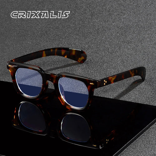 Un paio di occhiali wayfarer retro vintage unisex anti luce blu con lenti colorate blu è raffigurato su una superficie nera riflettente, con il marchio PACOSHOP24.COM in bianco nell'angolo in alto a sinistra.