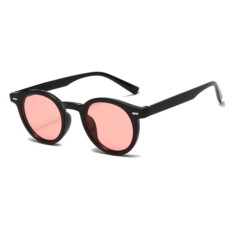 Occhiali da Sole Unisex stile Ovale moda di PACOSHOP24.COM con lenti UV400 rosa, mostrate su sfondo bianco da un'angolazione, ideali per uno stile moderno e alla moda.