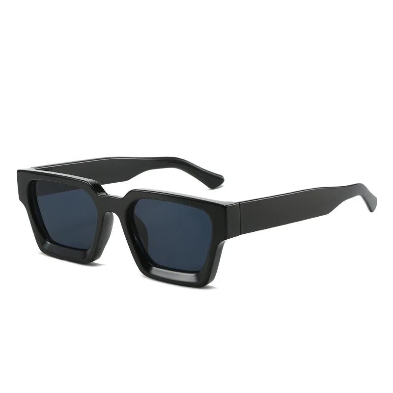 Gli Occhiali da sole con montatura quadrata Fashion Retrò Vintage di PACOSHOP24.COM sono caratterizzati da una spessa montatura nera e da lenti scure UV400, esposte ad angolo su sfondo bianco.