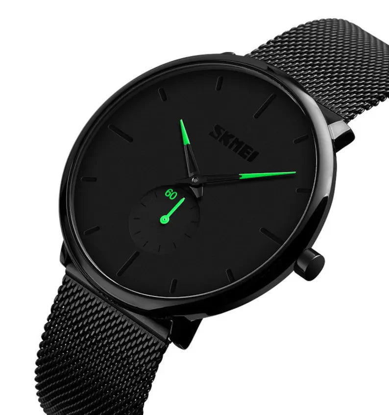 Lo Skmei Orologio minimalista ultraleggero ultrasottile nero verde presenta un elegante cinturino in maglia nera, lancette verdi, un piccolo quadrante secondario e un quadrante minimalista senza numeri per un look moderno ed elegante.