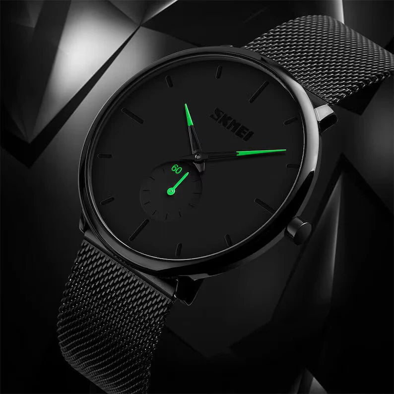 Lo Skmei Orologio minimalista ultraleggero ultrasottile nero verde presenta un elegante cinturino in maglia, un quadrante minimalista e lancette verdi luminose, su uno sfondo geometrico scuro.