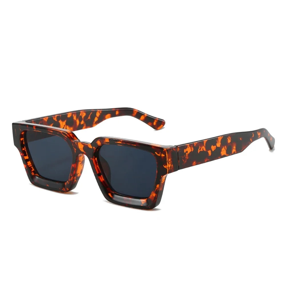 Occhiali da sole con montatura quadrata Fashion Retrò Vintage di PACOSHOP24.COM, con montatura tartarugata e lenti scure UV400, visualizzati ad angolo su sfondo bianco.