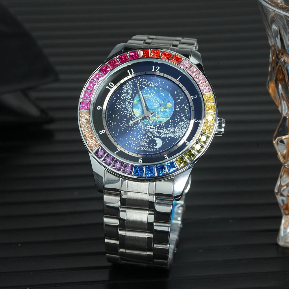 L'Orologio automatico uomo cielo stellato Design luminoso di PACOSHOP24.COM è caratterizzato da una cassa argentata, un quadrante cielo stellato e una lunetta con gemme multicolori, che poggia su una superficie scura e rigata accanto a un oggetto in vetro.