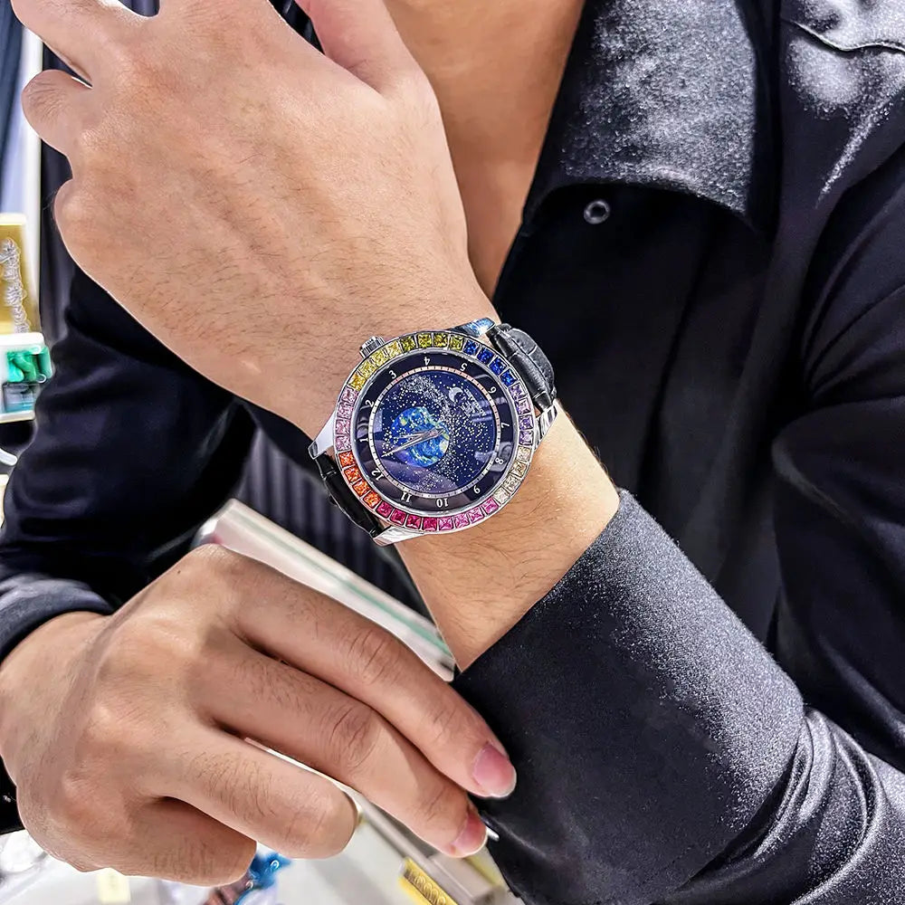 Una persona in camicia nera lucida mette in mostra l'Orologio automatico PACOSHOP24.COM uomo cielo stellato Design luminoso, caratterizzato da una lunetta colorata e scintillante e da un quadrante intricato, mentre appoggia la mano su una vetrina.