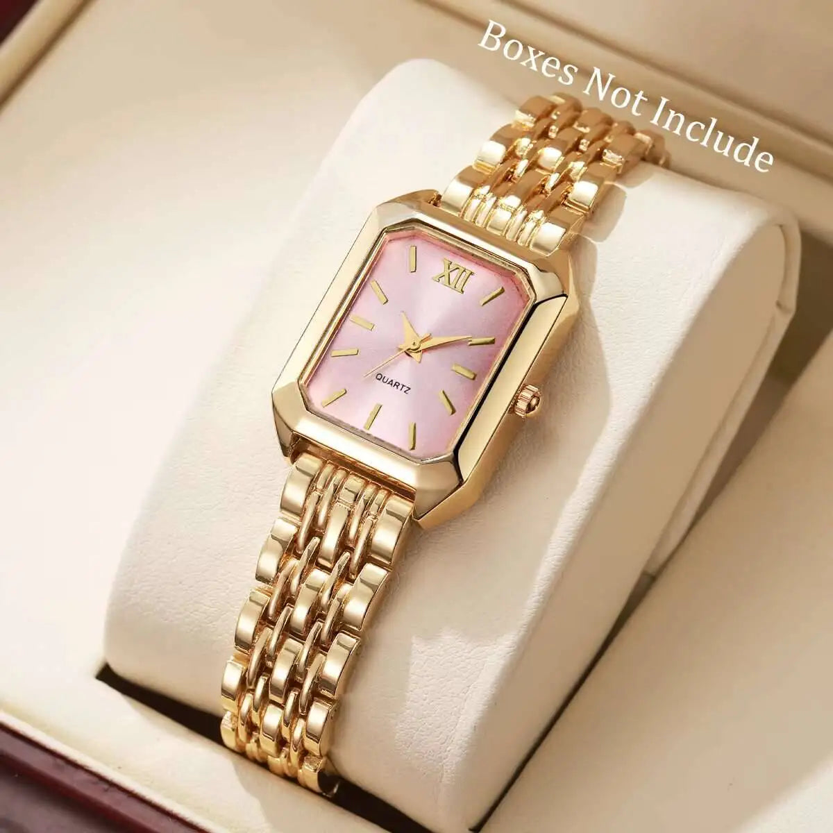Un orologio alla moda PACOSHOP24.COM al quarzo donna rettangolare con fascia in oro e quadrante rosa con numero romano XII è mostrato su un cuscino bianco in una scatola. Nell'angolo in alto a destra è riportata la dicitura "Scatola non inclusa".