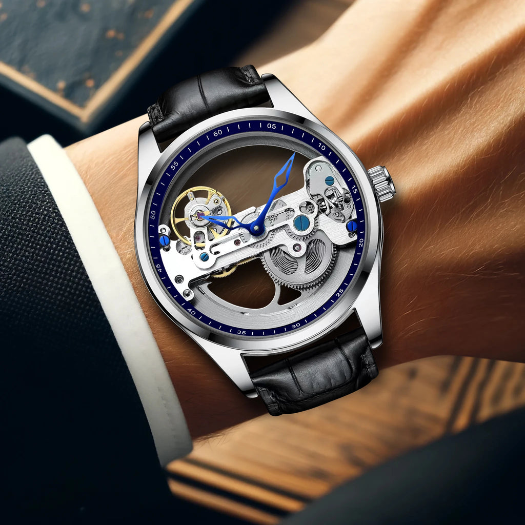 Primo piano di un polso che indossa l'Orologio automatico unisex alla moda stile scheletro tourbillon Limited Edition, con ingranaggi a vista e lancette blu, abbinato a un cinturino in pelle nera sotto la manica di un abito scuro.