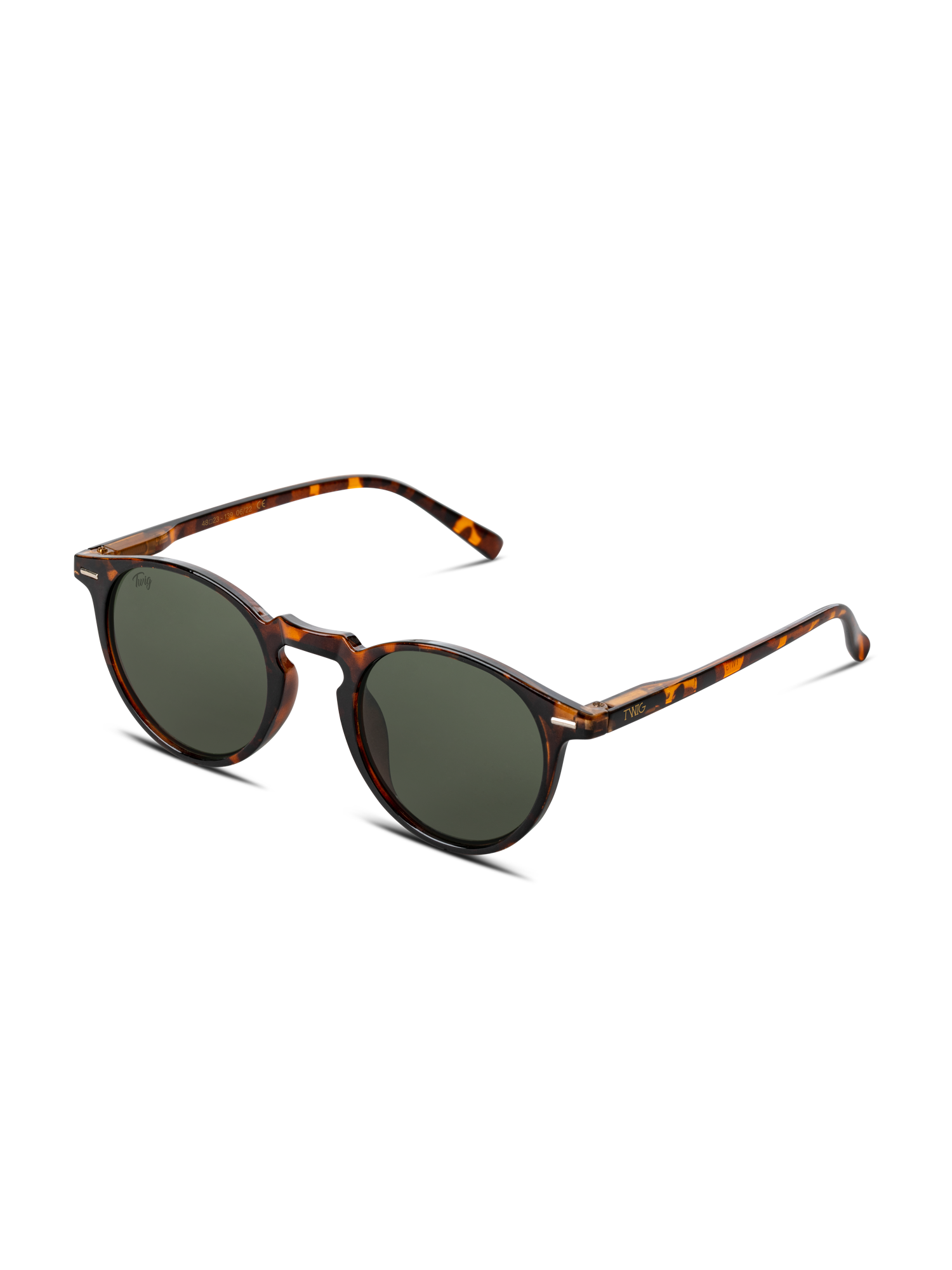 Gli Occhiali da sole Watson di TWIG Concept Milano sono occhiali da sole rotondi unisex in tartaruga con lenti verde scuro e protezione UV 400, disposti ad angolo su sfondo bianco.
