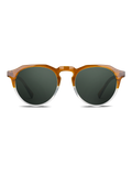 Occhiali da sole Woolf di TWIG Concept Milano: occhiali da sole rotondi unisex con lenti verde scuro e montatura in policarbonato trasparente ambrato sfumato. La protezione UV 400 garantisce una sicurezza ottimale degli occhi. In foto, su sfondo bianco.