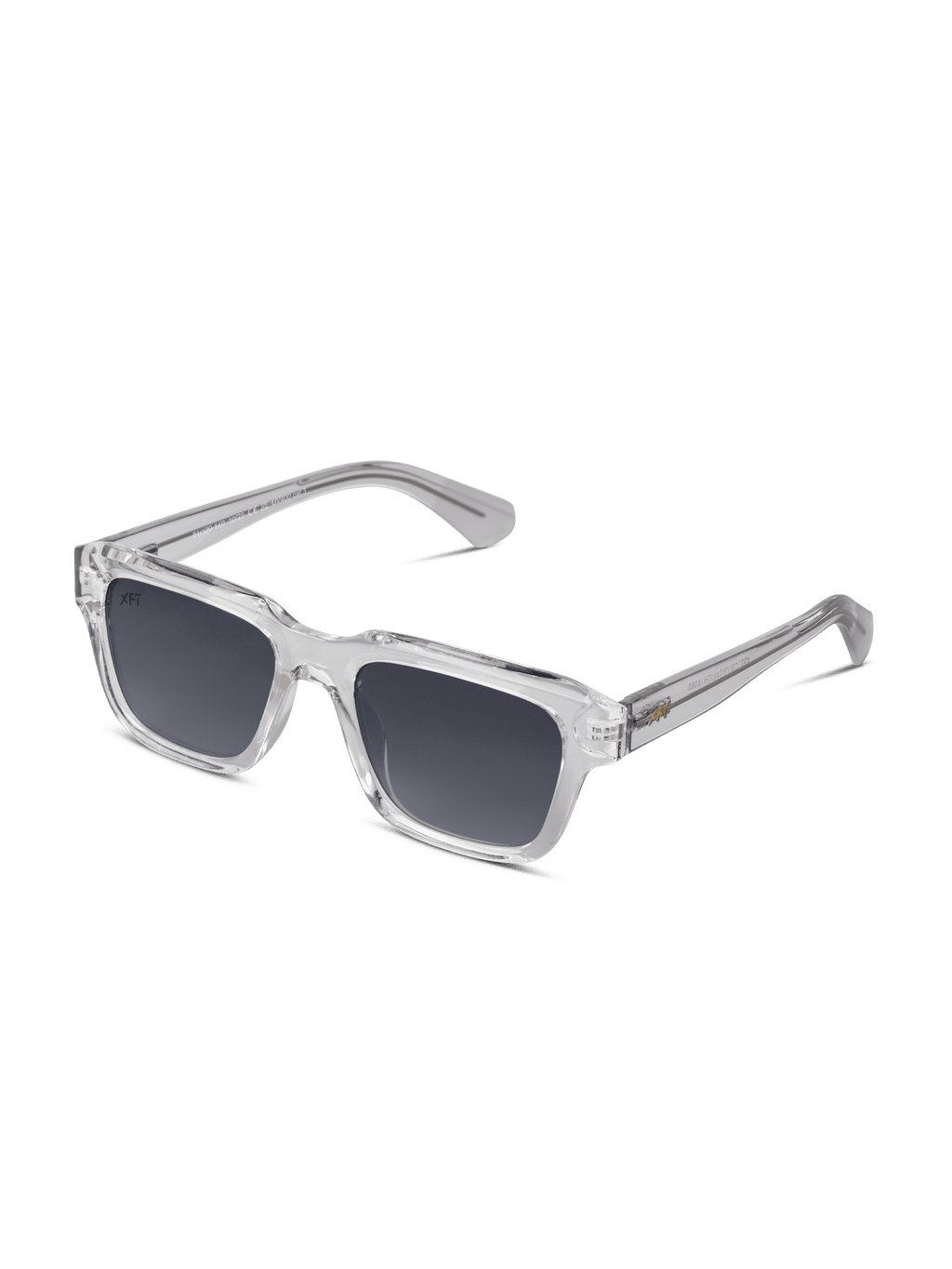 Gli occhiali da sole unisex X Frame Therapy Crystalith sono caratterizzati da una spessa montatura rettangolare in acetato di cellulosa trasparente, lenti scure e stanghette trasparenti con accenti metallici sulle cerniere, su sfondo bianco.