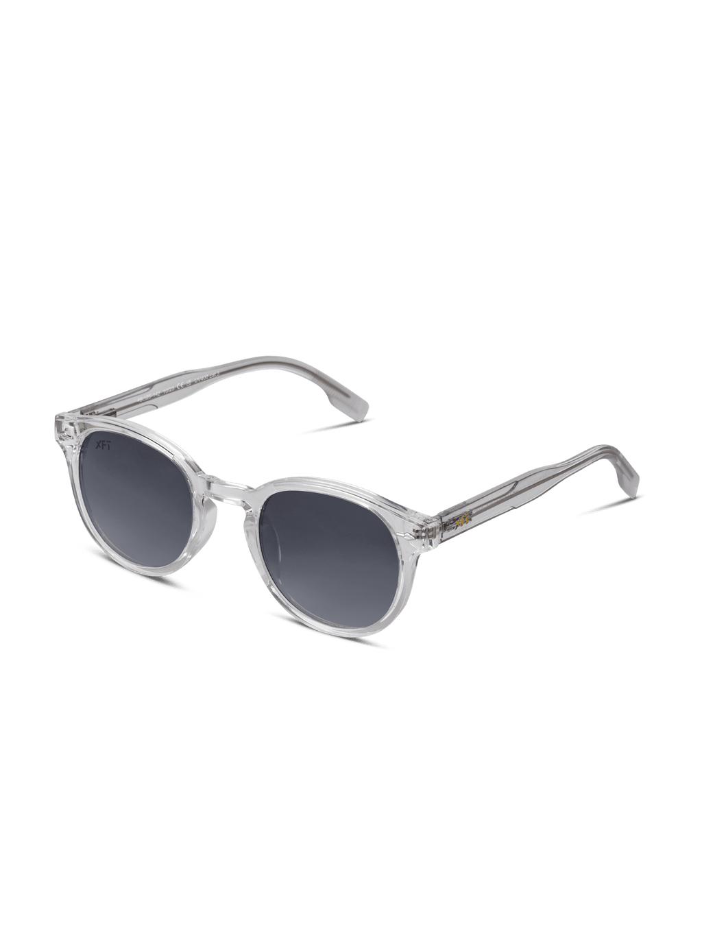 Gli occhiali da sole Luminatrix di X Frame Therapy, con montatura trasparente in acetato di cellulosa, lenti rotonde scure e aste spesse, offrono protezione UV e sono presentati su uno sfondo bianco.