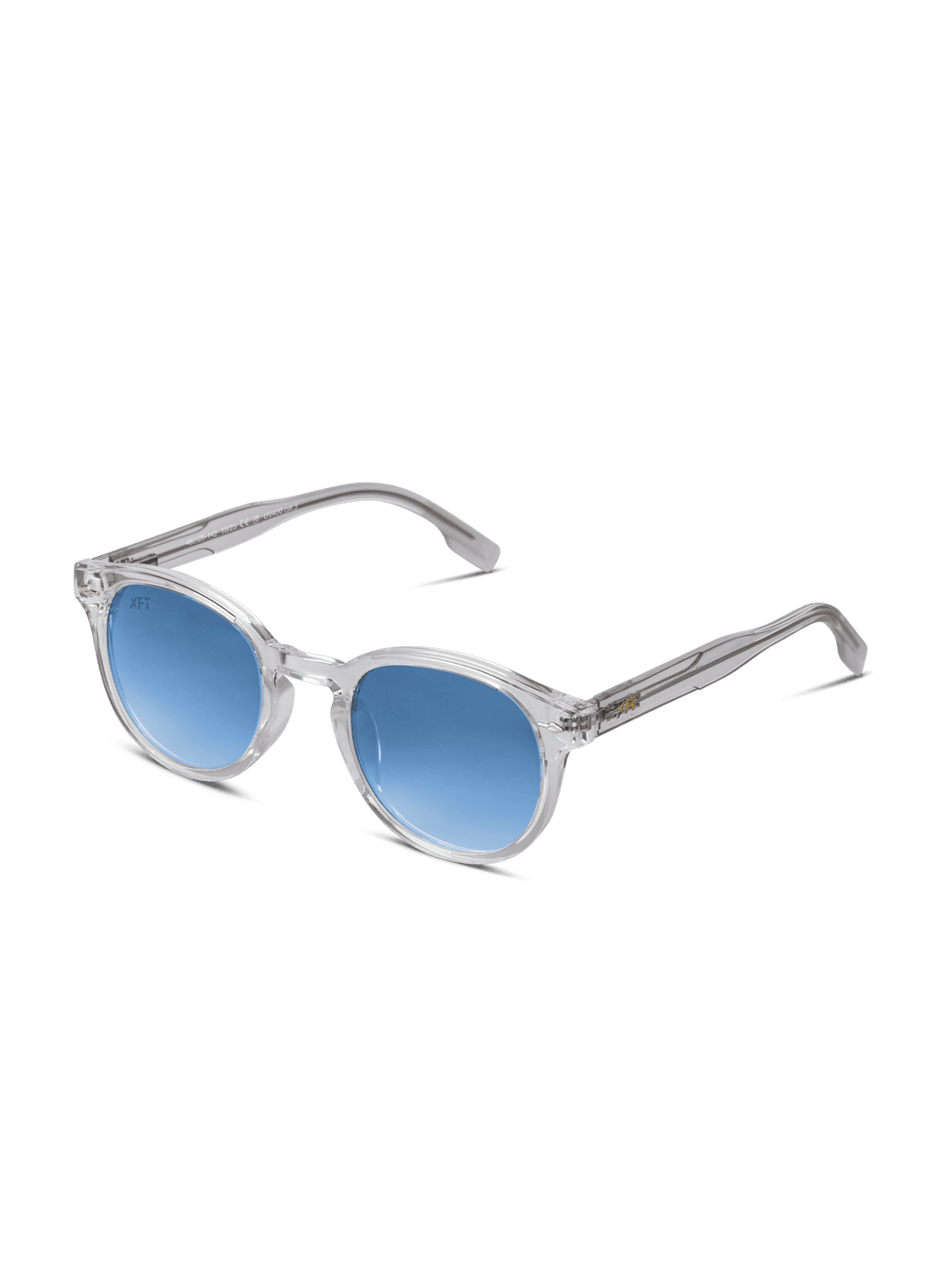 Luminatrix di X Frame Therapy è caratterizzato da montatura trasparente, lenti rotonde blu con protezione UV e stanghette trasparenti. Su sfondo bianco, questi occhiali da sole unisex offrono un look moderno ed elegante.