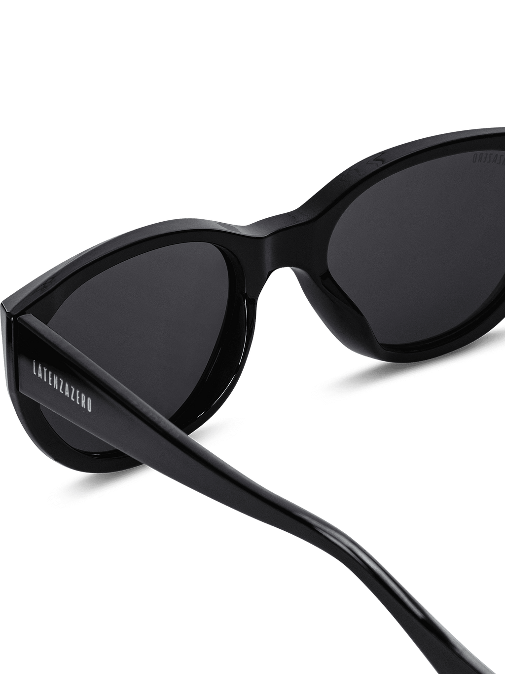 Primo piano degli occhiali da sole Apex Unisex Cat-Eye di Latenzazero in acetato nero. Lenti polarizzate UV400 e scritta "LATENZAZERO" incisa in bianco sulla stanghetta sinistra, su sfondo bianco.