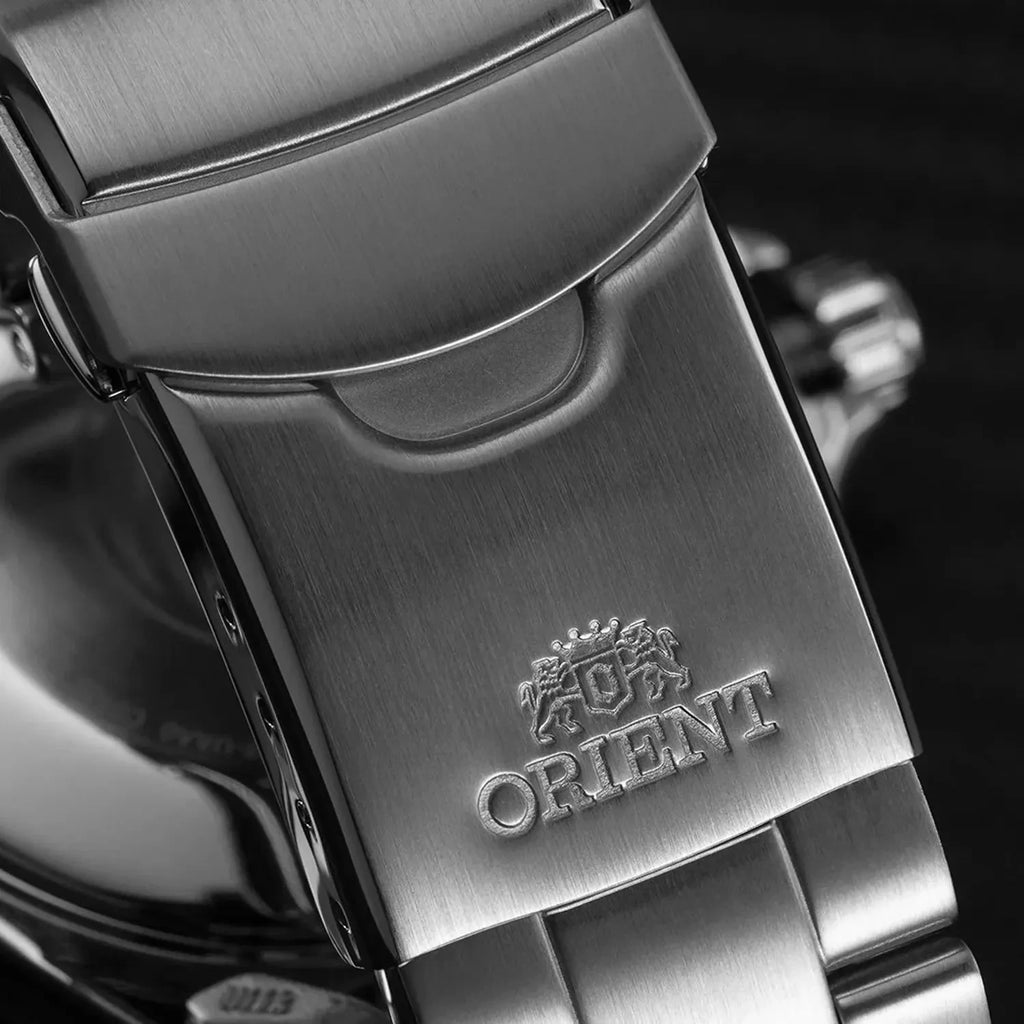 Primo piano della chiusura in metallo spazzolato dell'Orient Mako III Automatico RA-AA0002L39B, con l'incisione del logo e dell'emblema Orient; parte del quadrante dell'orologio è sfocato sullo sfondo.