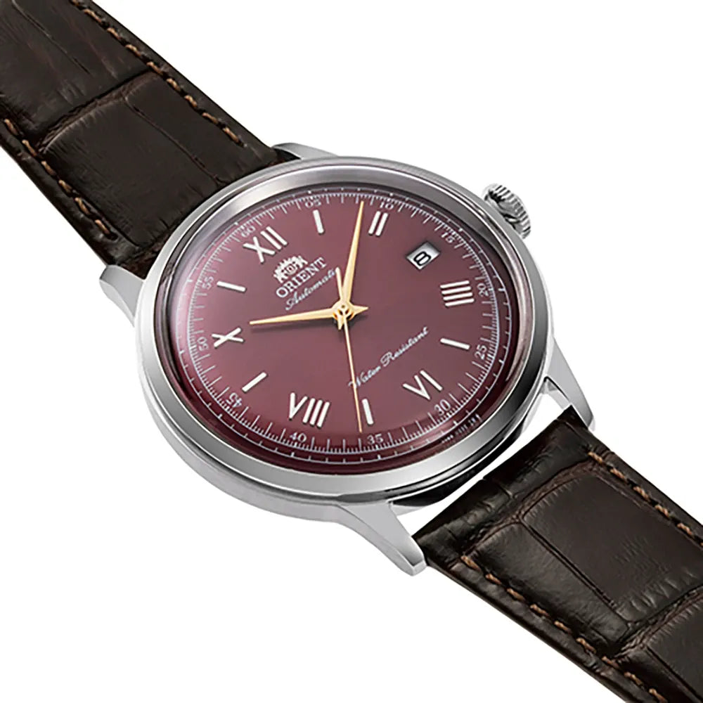 L'Orient Bambino Automatico RA-AC0026R30B è un orologio classico da uomo con cinturino in pelle marrone, quadrante bordeaux, lancette argentate, indici a numeri romani e datario a finestrella a ore 3. L'eleganza incontra la precisione in questo Orient Bambino Automatico. L'eleganza incontra la precisione in questo Orient orologio uomo.