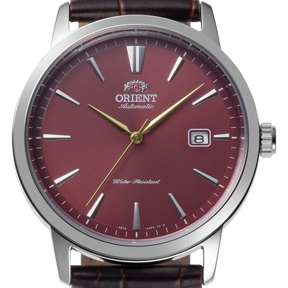Primo piano dell'Orient Bambino RA-AC0F15R30B, orologio automatico da uomo di Orient con quadrante rosso, lancette dorate, indici argentati, datario a ore 3, cinturino in pelle marrone e resistenza all'acqua.