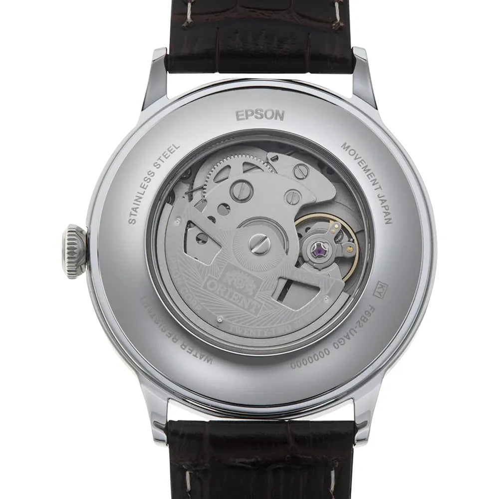 L'immagine mostra il retro dell'Orient Bambino Automatico RA-AK0702Y30B di Orient, con la cassa trasparente che rivela il suo intricato movimento. Questo orologio elegante uomo presenta una cassa in acciaio e un cinturino in pelle scura per un'eleganza classica.