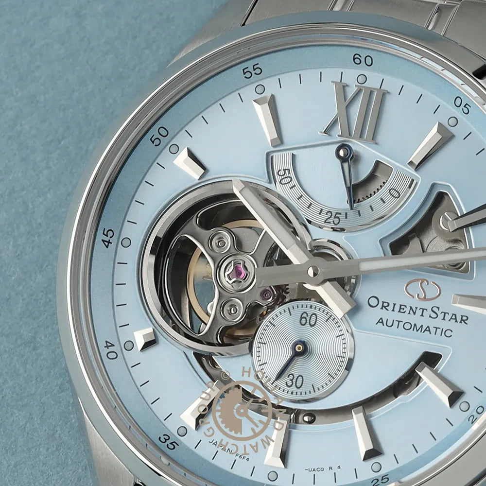 Primo piano dell'Orient Star Modern Skeleton Keshiki Limited Edition Automatic RE-AV0127L00B di Orient, con quadrante blu chiaro, ingranaggi a vista, quadrante dei piccoli secondi, indicatore della riserva di carica, indici e lancette argentati.