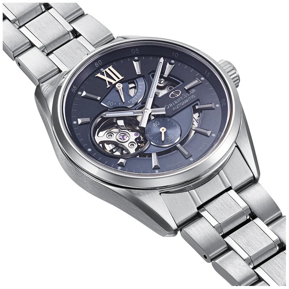 L'Orient Star Modern Skeleton Keshiki Limited Edition RE-AV0132L00B di Orient è un orologio automatico da uomo in acciaio inossidabile color argento con quadrante scheletrato blu, ingranaggi interni a vista e numero romano XII, raffigurato angolato su sfondo bianco.