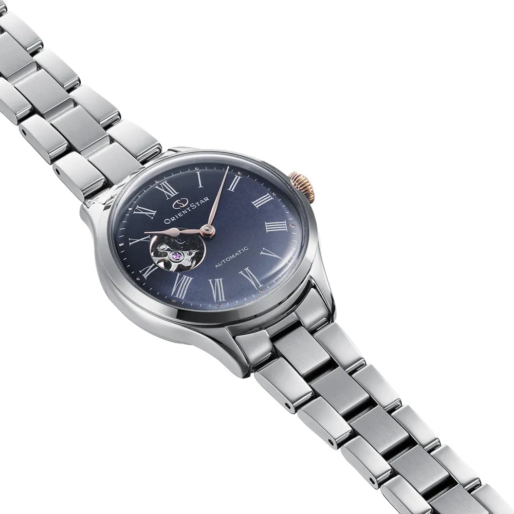L'Orient Star Classic Automatico RE-ND0022L00B di Orient è un orologio da donna in argento con bracciale metallico, quadrante blu con numeri romani, finestrella a cuore aperto e corona in oro, un elegante esempio di orologeria giapponese.