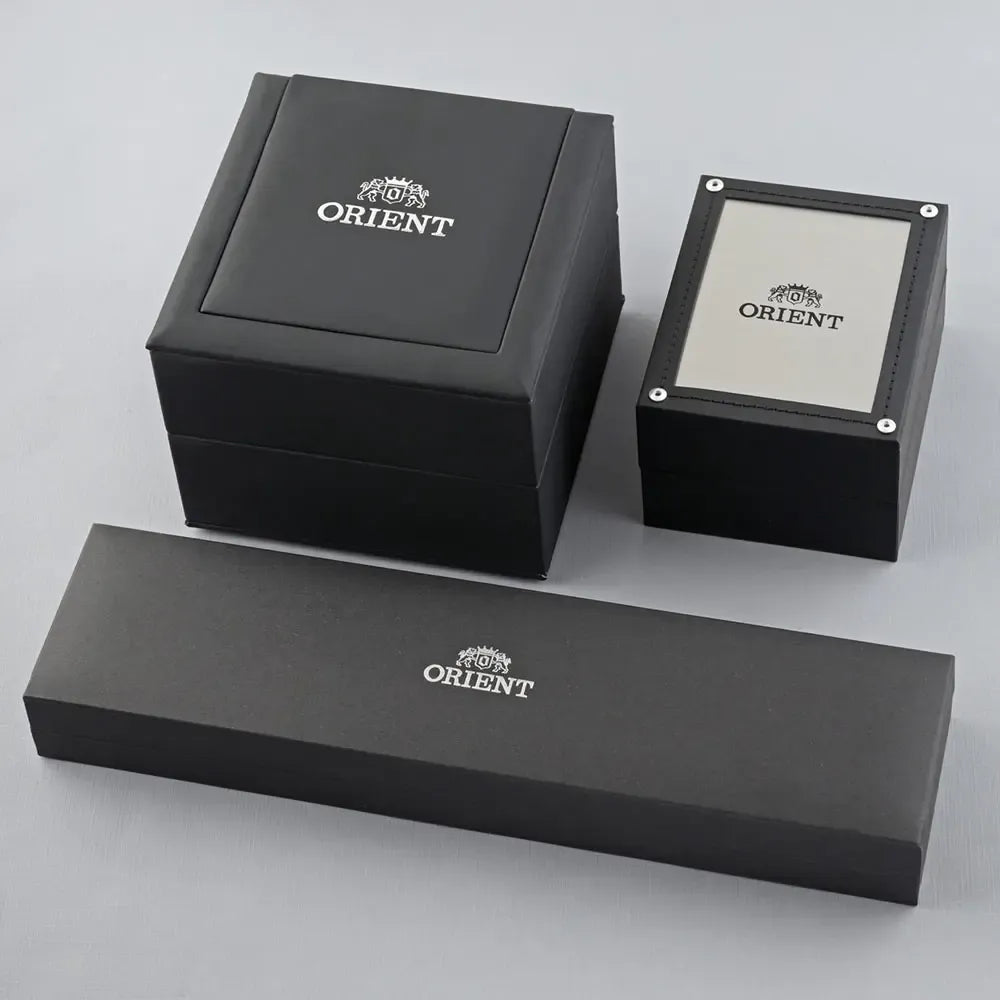 Tre scatole nere per orologi Orient, ciascuna con il logo Orient bianco, sono esposte su una superficie grigio chiaro, ideale per mettere in mostra il vostro Orient Bambino Automatico RA-AP0101B30B.